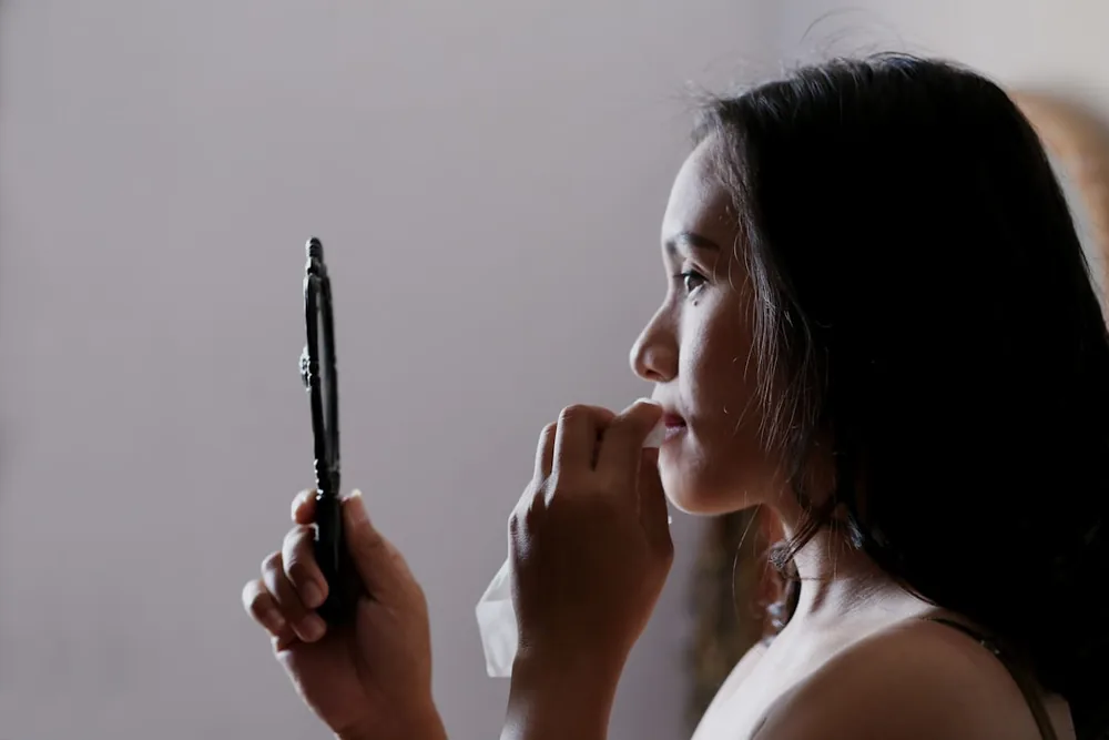 手鏡で肌を確かめる女性
